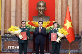 Chủ tịch nước Lương Cường trao Quyết định thăng quân hàm từ Trung tướng lên Thượng tướng đối với ông Đỗ Xuân Tụng, Phó Chủ nhiệm Tổng cục Chính trị Quân đội nhân dân Việt Nam và ông Đỗ Văn Bảnh, Chính ủy Học viện Quốc phòng. (Ảnh: Lâm Khánh/TTXVN)
