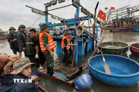 Bộ đội Biên phòng Cửa khẩu cảng Nghi Sơn cùng lực lượng chức năng, Tổ đoàn kết trên biển cùng chủ tàu và các ngư dân trong khu vực hỗ trợ trục vớt tài sản, đồng thời lai dắt phương tiện vào gần bờ để xử lý và khắc phục hậu quả. (Ảnh: TTXVN phát)