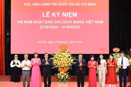 Giáo sư-Tiến sỹ Nguyễn Xuân Thắng, Ủy viên Bộ Chính trị, Giám đốc Học viện Chính trị Quốc gia Hồ Chí Minh, Chủ tịch Hội đồng Lý luận Trung ương tặng hoa chúc mừng Liên chi hội Nhà báo Học viện. (Ảnh: Minh Đức/TTXVN)