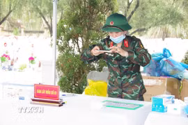 Thiếu tá quân nhân chuyên nghiệp Nguyễn Thị Thanh Thủy thực hiện nhiệm vụ số hóa hồ sơ tại Nghĩa trang Liệt sỹ Hàm Rồng. (Ảnh: TTXVN phát)