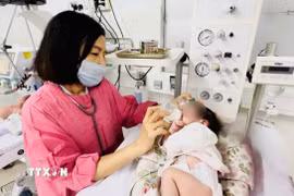 Mẹ và bé trai sơ sinh sau phẫu thuật trong phòng Hồi sức sơ sinh, Bệnh viện Đa khoa tỉnh Khánh Hòa. (Ảnh: TTXVN phát)