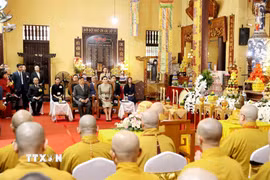 Nhà vua Thái Lan Maha Vajiralongkorn Phra Vajiraklaochaoyuhua và Hoàng hậu Suthida Bajrasudhabimalalakshana thực hiện nghi lễ thắp nến cầu an tại chùa Quán Sứ. (Ảnh: An Đăng/TTXVN)