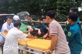 Sản phụ được khiêng từ vùng cô lập đến cơ sở y tế. (Ảnh: TTXVN phát)