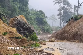 Một tảng đá nặng hàng tấn rơi xuống đường nối xã Trường Sơn với xã Trường Ninh. (Ảnh: TTXVN phát)