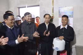Phó Thủ tướng, Bộ trưởng Ngoại giao Bùi Thanh Sơn cùng lãnh đạo tỉnh Điện Biên tặng nồi cơm điện cho người dân bản Nặm Cứm, xã Ngối Cáy. (Ảnh: Xuân Tư/TTXVN)