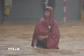 Người dân di chuyển khó khăn tại khu vực nước sâu. (Ảnh: Văn Dũng/TTXVN)