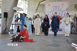 Ca sỹ Thanh Lam (áo đen đứng giữa) hát nền trong phần trình diễn áo dài của nhà thiết kế Minh Hạnh tại sự kiện. (Ảnh: Hữu Chiến/TTXVN)