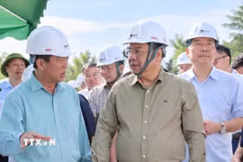 Phó Thủ tướng Thường trực Phạm Gia Túc nghe đại diện nhà thầu báo cáo tiến độ thi công tại công trường. (Ảnh: TTXVN phát)