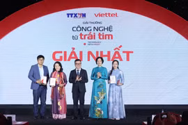 Tổng Giám đốc TTXVN Vũ Việt Trang và Chủ tịch Hội Nhà báo Việt Nam Lê Quốc Minh trao giải Nhất cho các tác giả đoạt giải. (Ảnh: Minh Quyết/TTXVN)