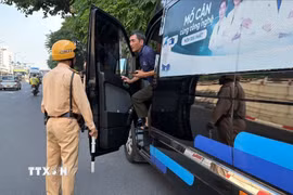 Lực lượng chức năng kiểm tra xe hợp đồng dừng bên đường trên tuyến Lê Duẩn-Giải Phóng, Hà Nội, sáng 21/9. (Ảnh: Trung Nguyên/TTXVN)