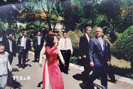Thượng tá Nguyễn Hữu Liệu (áo sơmi trắng) bảo vệ Tổng thống Mỹ George W. Bush khi thăm Viện Pasteur Thành phố Hồ Chí Minh. (Ảnh: TTXVN phát)