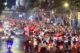 Cơn mưa xuyên suốt cả ngày không ngăn được niềm vui của người hâm mộ Thủ đô. (Ảnh: Minh Quyết/TTXVN)