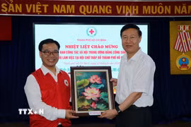 Ông Nguyễn Minh Nhựt, Chủ tịch Hội Chữ thập Đỏ Thành phố Hồ Chí Minh tặng quà lưu niệm ông Zhao Shi Tang, Phó Trưởng ban Ban Công tác xã hội Trung ương Đảng Cộng sản Trung Quốc. (Ảnh: Thanh Vũ/TTXVN)