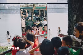 Các em nhỏ vui đùa với chong chóng. (Ảnh: Phạm Tuấn Anh/TTXVN)