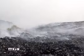 Khói vẫn bốc lên từ bãi rác dù đám cháy đã cơ bản được khống chế. (Ảnh: Văn Tý/TTXVN)