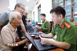 Cán bộ, chiến sỹ phòng PC06 lấy thông tin của thân nhân liệt sỹ tại địa bàn phường Điện Biên Phủ. (Ảnh: Trung Kiên/TTXVN)