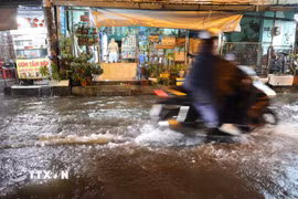 Nước dâng do mưa và triều cường, nguy cơ nước tràn vào nhà dân tối 30/9 trên đường Bình Quới, phường Bình Quới. (Ảnh: Hồng Đạt/TTXVN)