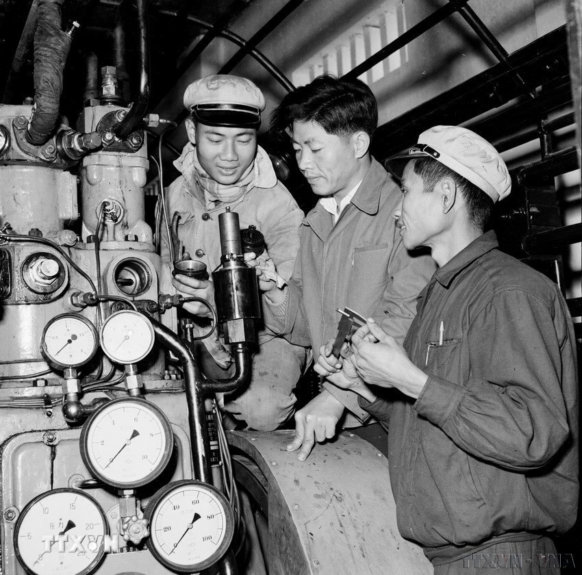 Chuyên gia Trung Quốc (giữa) hướng dẫn công nhân Việt Nam tháo lắp, tu sửa van thoát hơi nước tự động trong nhà máy ép K65 (9/1960). (Ảnh: Trần Phác/TTXVN)