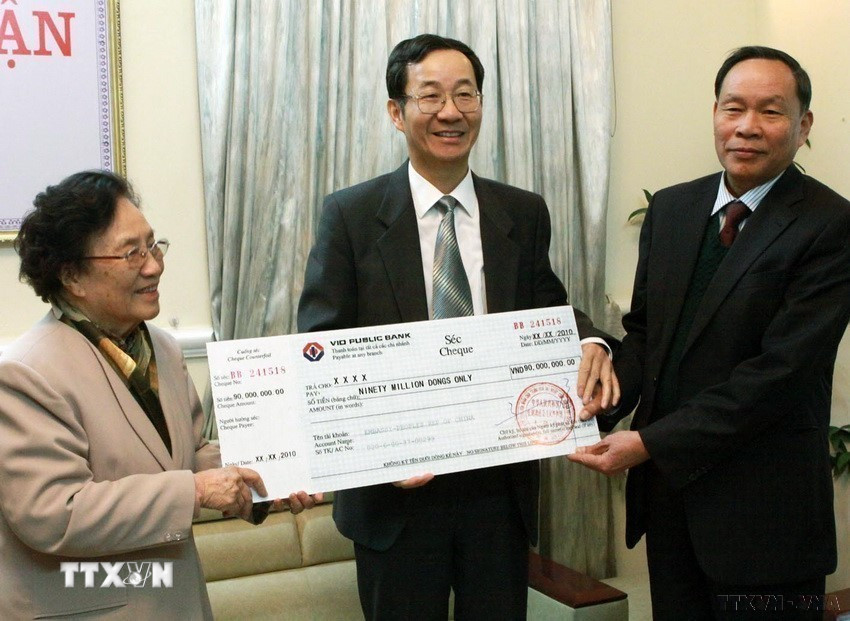 Đại diện Đại sứ quán Trung Quốc (giữa) trao tặng 90 triệu đồng cho Hội nạn nhân chất độc da cam/dioxin Việt Nam (VAVA), nhằm giúp điều trị, phục hồi chức năng và nâng cao chất lượng cuộc sống, sớm hòa nhập cộng đồng cho nạn nhân da cam (11/3/2010). (Ảnh: Dương Ngọc/TTXVN)
