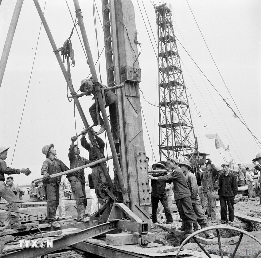 Công nhân kỹ thuật Trung Quốc và Việt Nam điều khiển máy đóng cọc để làm đê quai xanh chắn nước trong thi công xây dựng triền tàu Nhà máy đóng tàu Hải Phòng (1960). (Ảnh: Lâm Hồng/TTXVN)