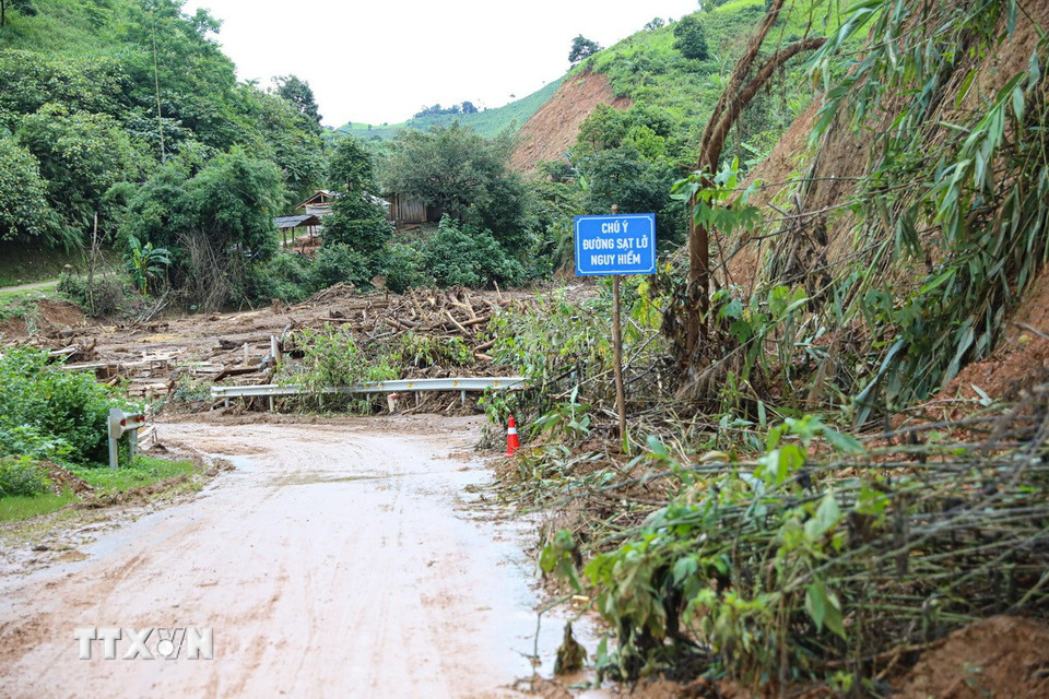 Lực lượng chức năng cắm biển cảnh báo để các phương tiện tham gia giao thông được an toàn khi lưu thông. (Ảnh: Phan Quân/TTXVN)