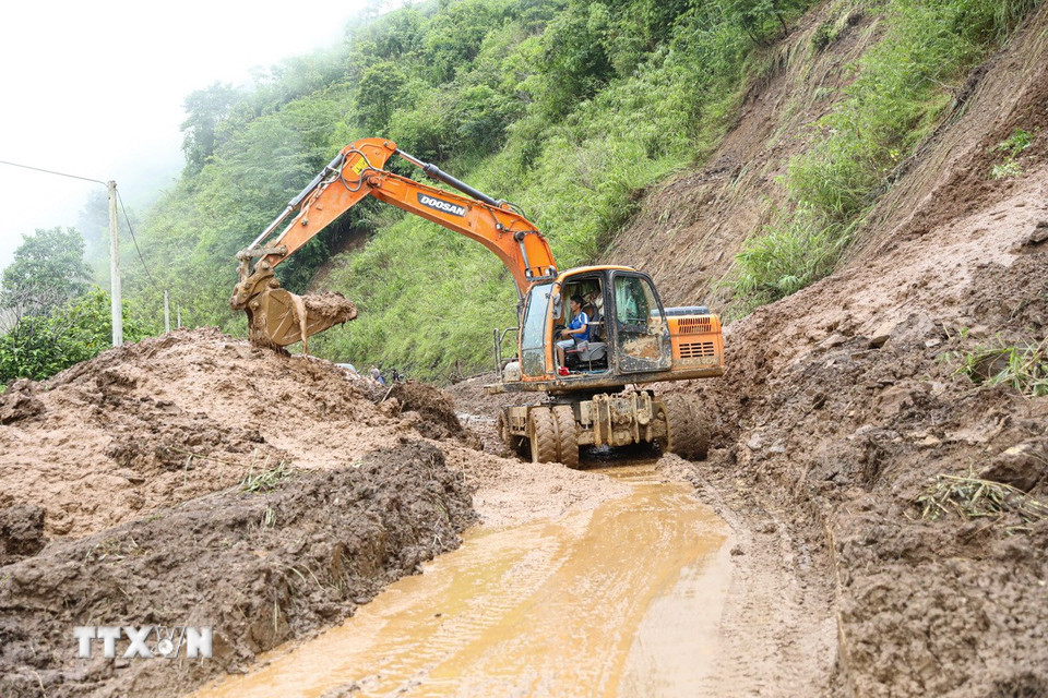 Công ty Cổ phần Đường bộ 2 Điện Biên, đã huy động máy móc gồm máy xúc, máy ủi và các phương tiện chuyên dụng để kịp thời thông tuyến vào sáng 6/8. (Ảnh: Phan Quân/TTXVN)