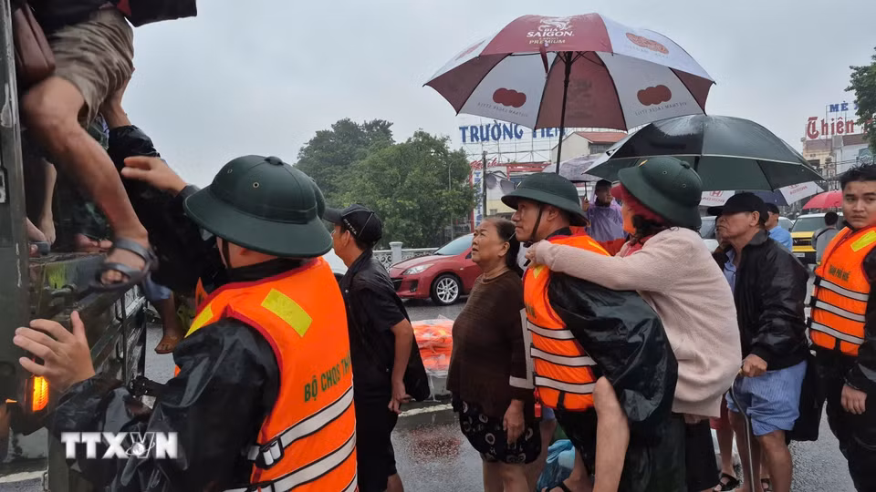 Lực lượng vũ trang Huế hỗ trợ di dời dân, tài sản khỏi khu vực nguy hiểm. (Ảnh: TTXVN phát)