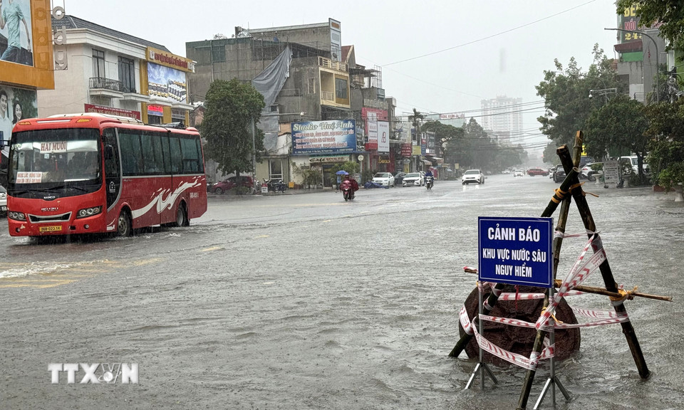 Tuyến đường huyết mạch Nguyễn Trãi, phường Hạc Thành, tỉnh Thanh Hóa ngập, phải dựng biển cảnh báo cho phương tiện tham gia giao thông. (Ảnh: Việt Hoàng/TTXVN)