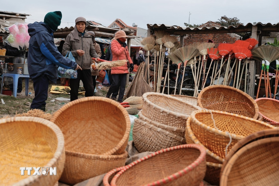 Người dân đi chợ Vé phiên cuối năm. (Ảnh: Minh Quyết/TTXVN)