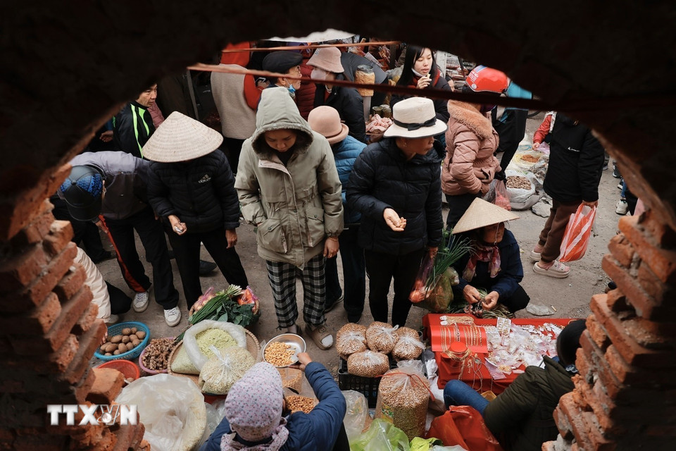 Người dân đi chợ mua sắm chuẩn bị cho Tết. (Ảnh: Minh Quyết/TTXVN)