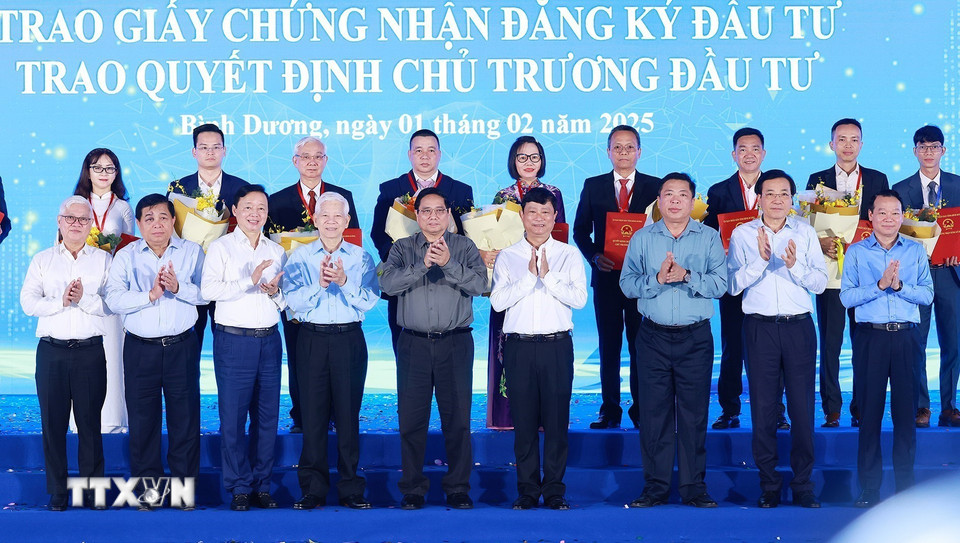 Thủ tướng Phạm Minh Chính và lãnh đạo tỉnh Bình Dương với các nhà đầu tư được trao giấy chứng nhận và quyết định chủ trương đầu tư. (Ảnh: Dương Giang/TTXVN)