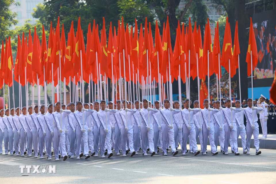 Khối cờ Đảng, cờ Tổ quốc tiến qua Lễ đài. (Ảnh: TTXVN)