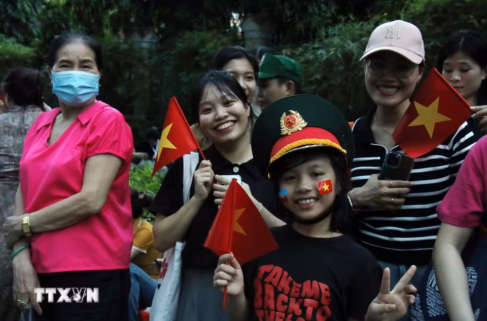 Các bạn nhỏ cũng háo hức cùng người thân đi xem diễu binh, diễu hành. (Ảnh: Tiến Lực/TTXVN)