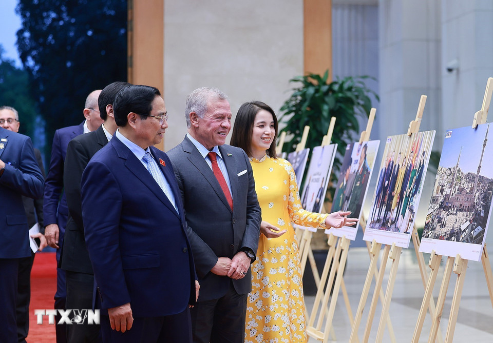Thủ tướng Phạm Minh Chính và Quốc vương Jordan Abdullah II Ibn Al Hussein tham quan trưng bày ảnh về quan hệ hợp tác giữa hai nước, do Thông tấn xã Việt Nam thực hiện. (Ảnh: Dương Giang/TTXVN)