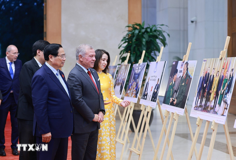Thủ tướng Phạm Minh Chính và Quốc vương Jordan Abdullah II Ibn Al Hussein tham quan trưng bày ảnh về quan hệ hợp tác giữa hai nước, do Thông tấn xã Việt Nam thực hiện. (Ảnh: Dương Giang/TTXVN)