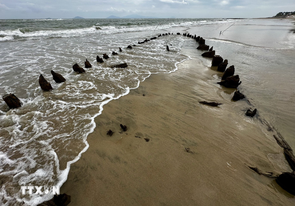 Con tàu lại bị ẩn dưới lớp cát biển mỗi khi thủy triều lên. (Ảnh: Trần Lê Lâm/TTXVN)