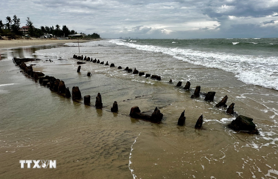 Phần khung gỗ con tàu nổi trên mặt cát. (Ảnh: Trần Lê Lâm/TTXVN)