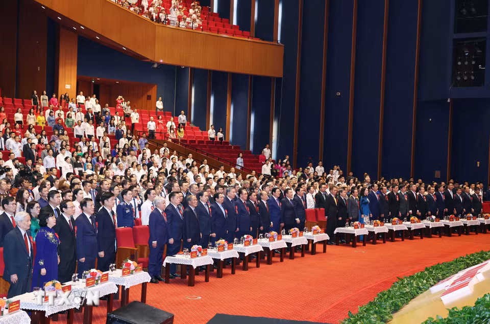 Các đồng chí lãnh đạo, nguyên lãnh đạo Đảng, Nhà nước và các đại biểu thực hiện nghi lễ chào cờ. (Ảnh: Thống Nhất/TTXVN)