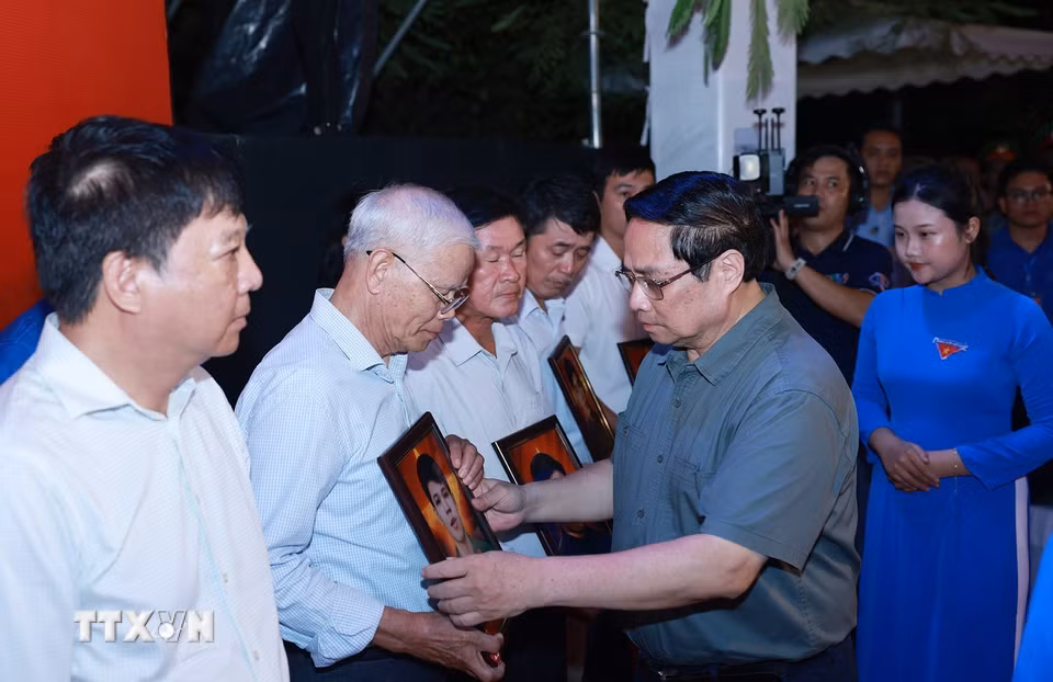 Thủ tướng Phạm Minh Chính trao chân dung liệt sỹ được phục dựng lại cho thân nhân liệt sỹ tại buổi lễ. (Ảnh: Dương Giang/TTXVN)