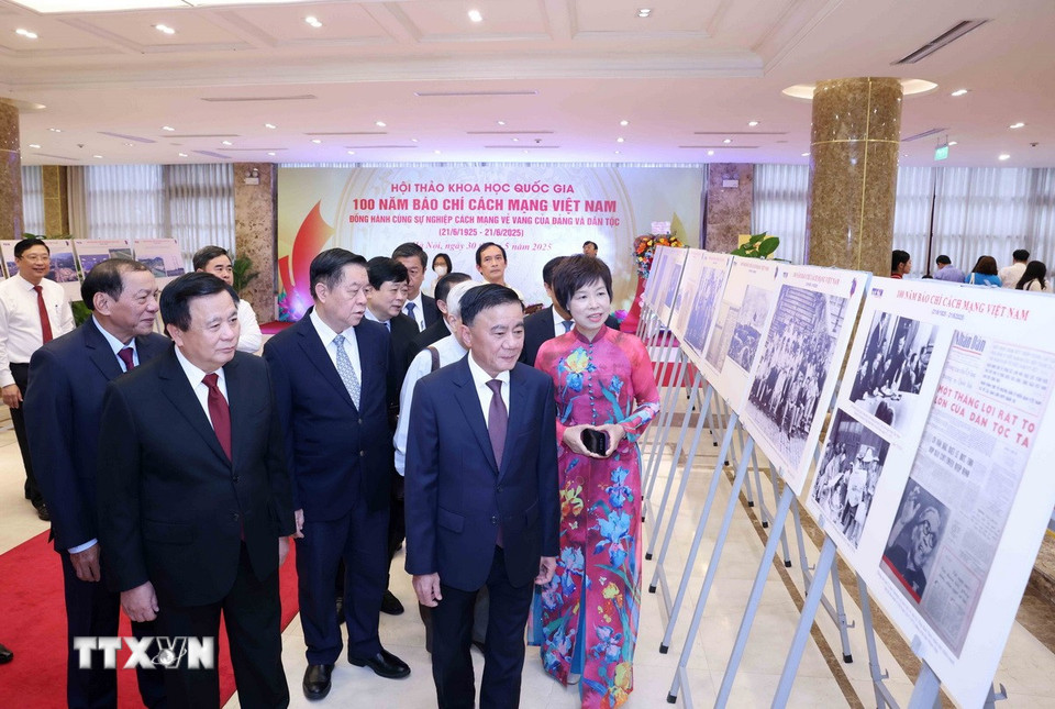 Tổng Giám đốc TTXVN Vũ Việt Trang giới thiệu trưng bày ảnh chuyên đề "100 năm Báo chí cách mạng Việt Nam" với các đại biểu dự hội thảo. (Ảnh: Phương Hoa/TTXVN)