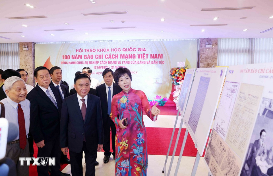 Tổng Giám đốc TTXVN Vũ Việt Trang giới thiệu trưng bày ảnh chuyên đề "100 năm Báo chí cách mạng Việt Nam" với các đại biểu dự hội thảo. (Ảnh: Phương Hoa/TTXVN)
