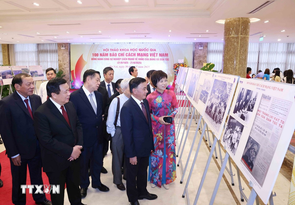 Tổng Giám đốc TTXVN Vũ Việt Trang giới thiệu trưng bày ảnh chuyên đề "100 năm Báo chí cách mạng Việt Nam" với các đại biểu dự hội thảo. (Ảnh: Phương Hoa/TTXVN)