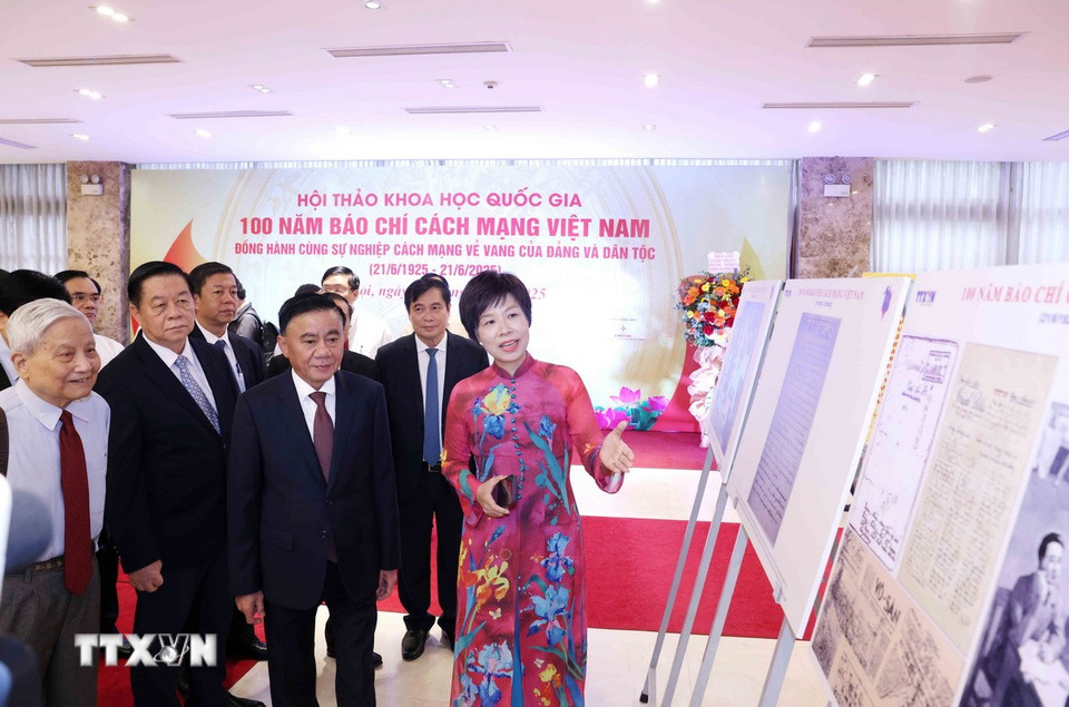 Tổng Giám đốc TTXVN Vũ Việt Trang giới thiệu trưng bày ảnh chuyên đề "100 năm Báo chí cách mạng Việt Nam" với các đại biểu dự hội thảo. (Ảnh: Phương Hoa/TTXVN)