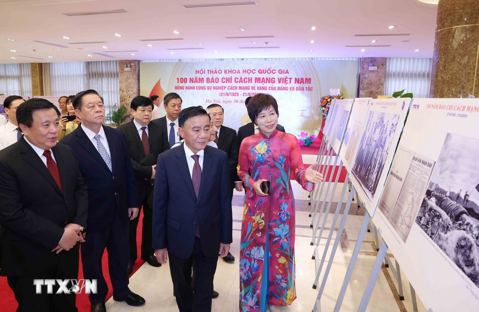 Tổng Giám đốc TTXVN Vũ Việt Trang giới thiệu trưng bày ảnh chuyên đề "100 năm Báo chí cách mạng Việt Nam" với các đại biểu dự hội thảo. (Ảnh: Phương Hoa/TTXVN)
