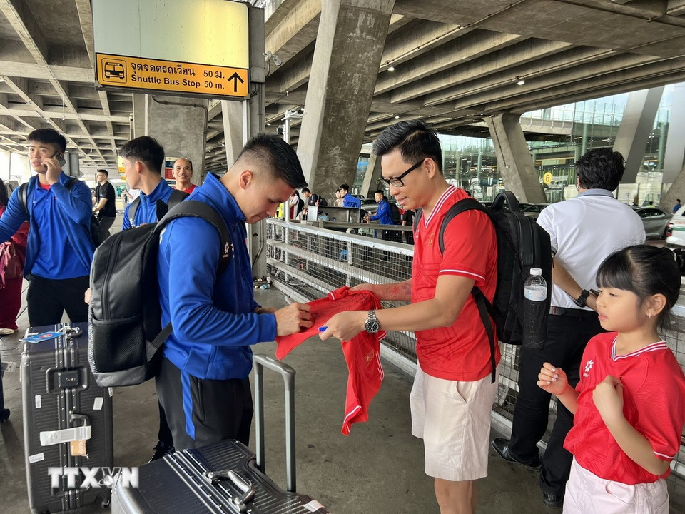 Tiền vệ Nguyễn Quang Hải ký tặng người hâm mộ Việt Nam tại sân bay. (Ảnh: Huy Tiến/TTXVN)