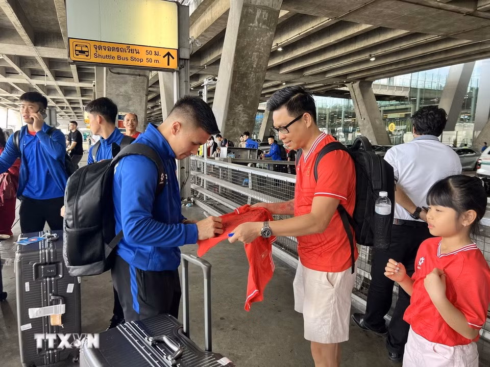 Tiền vệ Nguyễn Quang Hải ký tặng người hâm mộ Việt Nam tại sân bay. (Ảnh: Huy Tiến/TTXVN)
