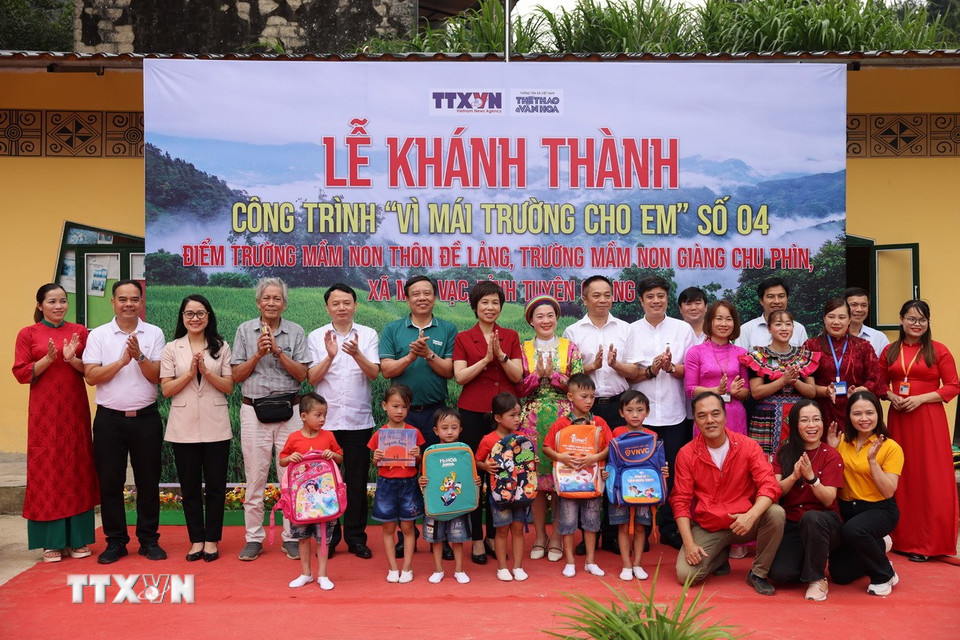 Nhà báo Vũ Việt Trang, Bí thư Đảng ủy, Tổng Giám đốc TTXVN và nhà báo Nguyễn Thiện Thuật, Tổng biên tập Báo Thể thao và Văn hóa tặng quà cho các em Trường Mầm non Đề Lảng. (Ảnh: Huy Thông/TTXVN)