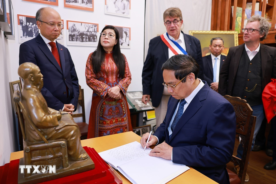 Thủ tướng Phạm Minh Chính viết lưu bút tại không gian trưng bày tư liệu, hiện vật về Chủ tịch Hồ Chí Minh. (Ảnh: Dương Giang/TTXVN)