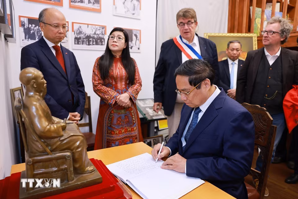 Thủ tướng Phạm Minh Chính viết lưu bút tại không gian trưng bày tư liệu, hiện vật về Chủ tịch Hồ Chí Minh. (Ảnh: Dương Giang/TTXVN)