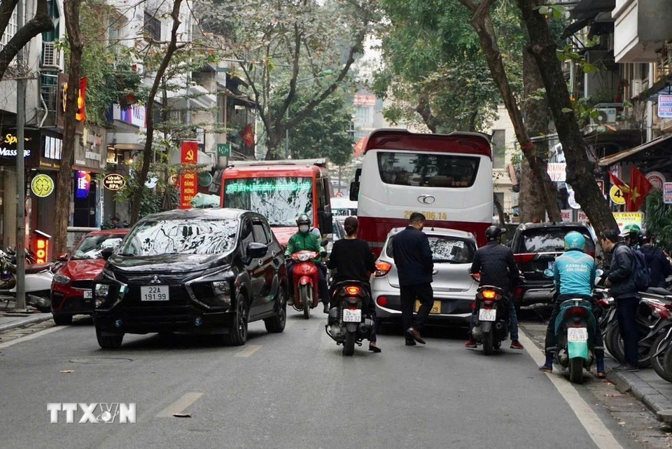 Lượng xe du lịch trên 16 chỗ ra vào phố Nguyễn Hữu Huân tăng cao sau giờ cao điểm. (Ảnh: Tú Anh/TTXVN phát)